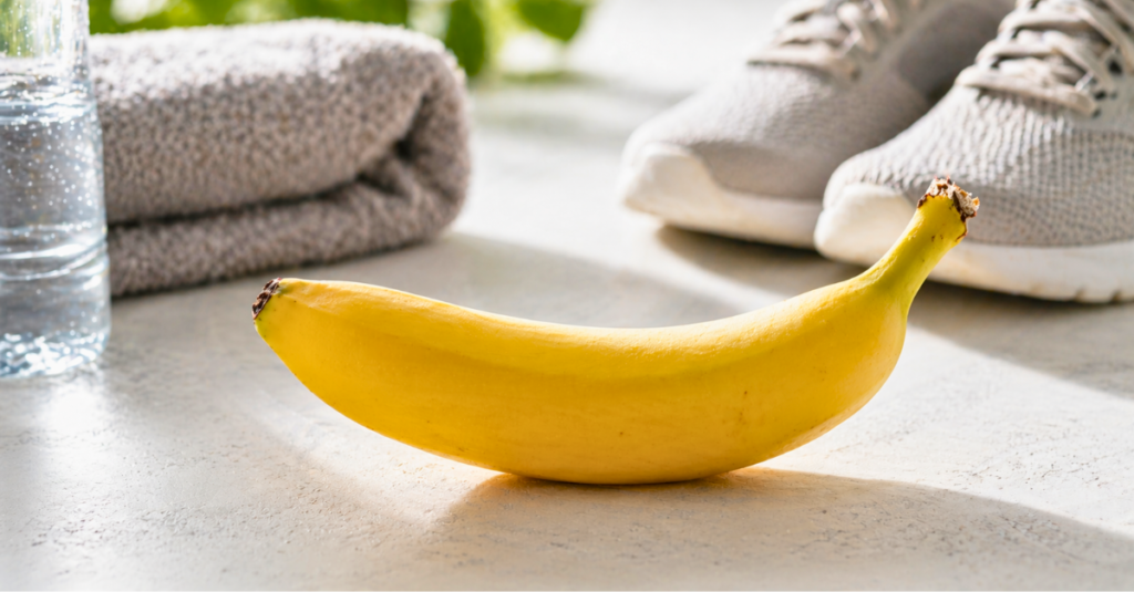motivos para comer banana antes do ginásio ilustrados com banana fresca em ambiente fitness com luz natural