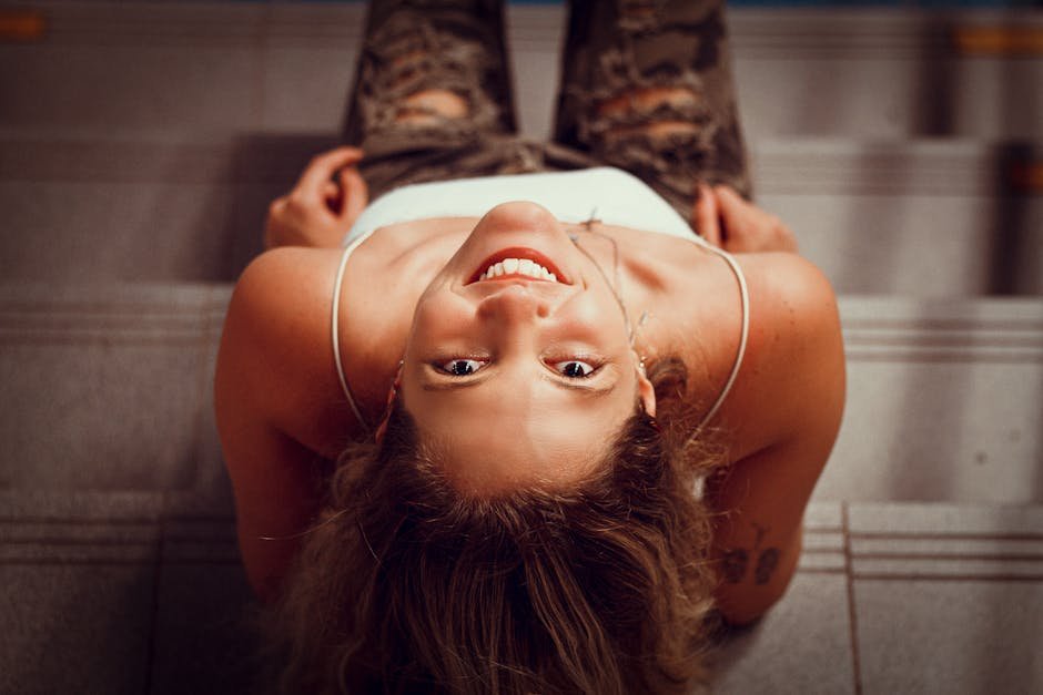 5 benefícios da exposição solar para a saúde 3 Mulher sorridente ao sol, captada de cima, ilustrando o benefícios da exposição solar no bem-estar e energia – Vida em Equilíbrio