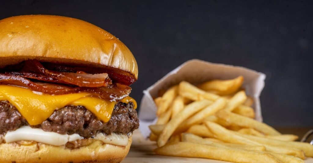 9 mitos sobre nutrição em que você ainda acredita 10 Hambúrguer com queijo e bacon acompanhado de batatas fritas, representando escolhas alimentares e mitos sobre nutrição no contexto do Vida em Equilíbrio