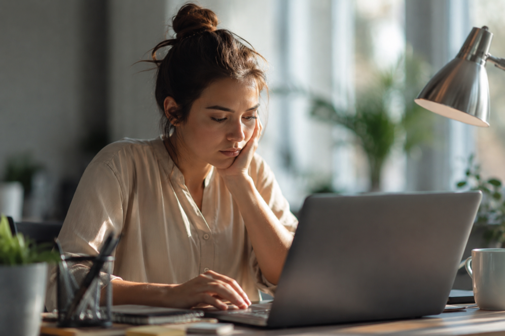 Resiliência Psicológica: o amortecedor contra a depressão **Alt text:**
Mulher cansada a trabalhar ao computador representando depressão e baixa resiliência psicológica em ambiente profissional silencioso