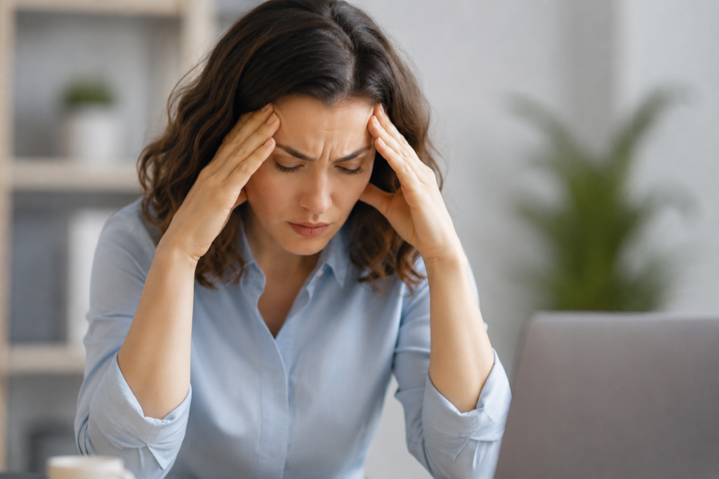 Mulher com expressão cansada e preocupada, representando os efeitos do cortisol elevado no cérebro e no corpo